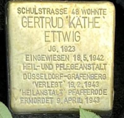 Quadratischer Stolperstein aus Messing gewidmet Gertrud Käthe Ettwig mit der Gravur: Schulstrasse 48 wohnte Gertrud 'Käthe' Ettwig, JG. 1923, Eingewisen 18.5.1942 Heil- und Pflegeanstalt Düsseldorf-Grafenberg, 'Verlegt' 19.2.1943 'Heilanstalt' Pfaffenrode, Ermordet 9. April 1943.